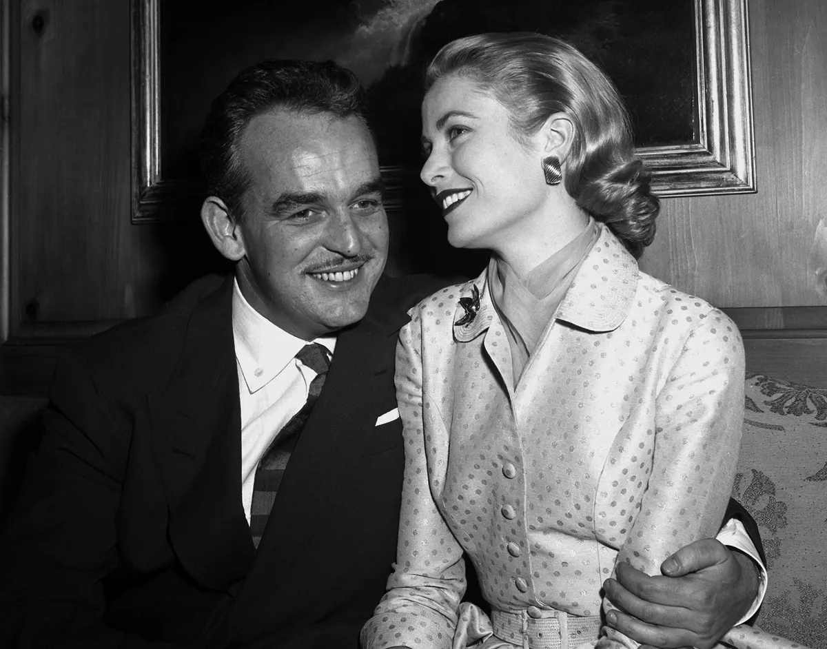 Prince Rainier III of Monaco and Grace Kelly, 26, pose for photographers at the Kelly home in Philadelphia after announcing their engagement yesterday.