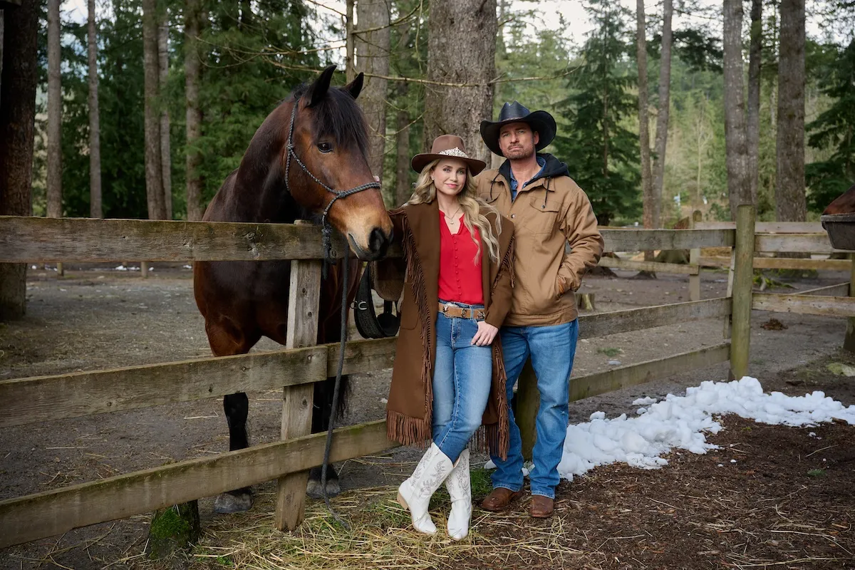 A man and a woman standing in front of a horse in 'A Royal Montana Christmas' on Hallmark Channel