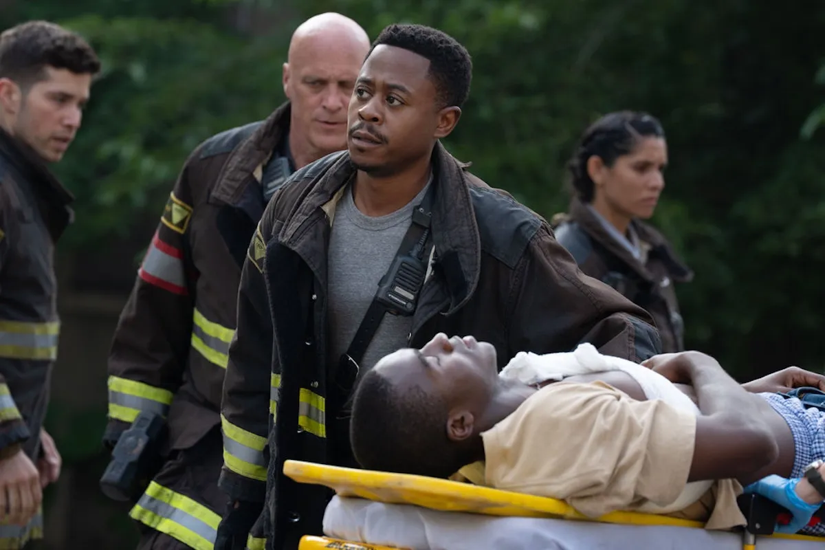 Ritter standing next to a man on a stretcher in the 'Chicago Fire' Season 14 premiere