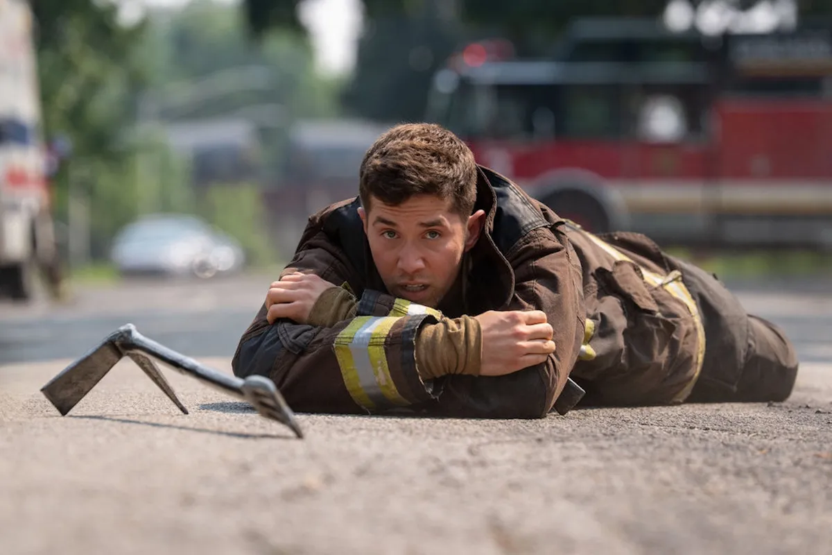 Man in firefighting gear lying on the ground in the 'Chicago Fire' Season 14 premiere