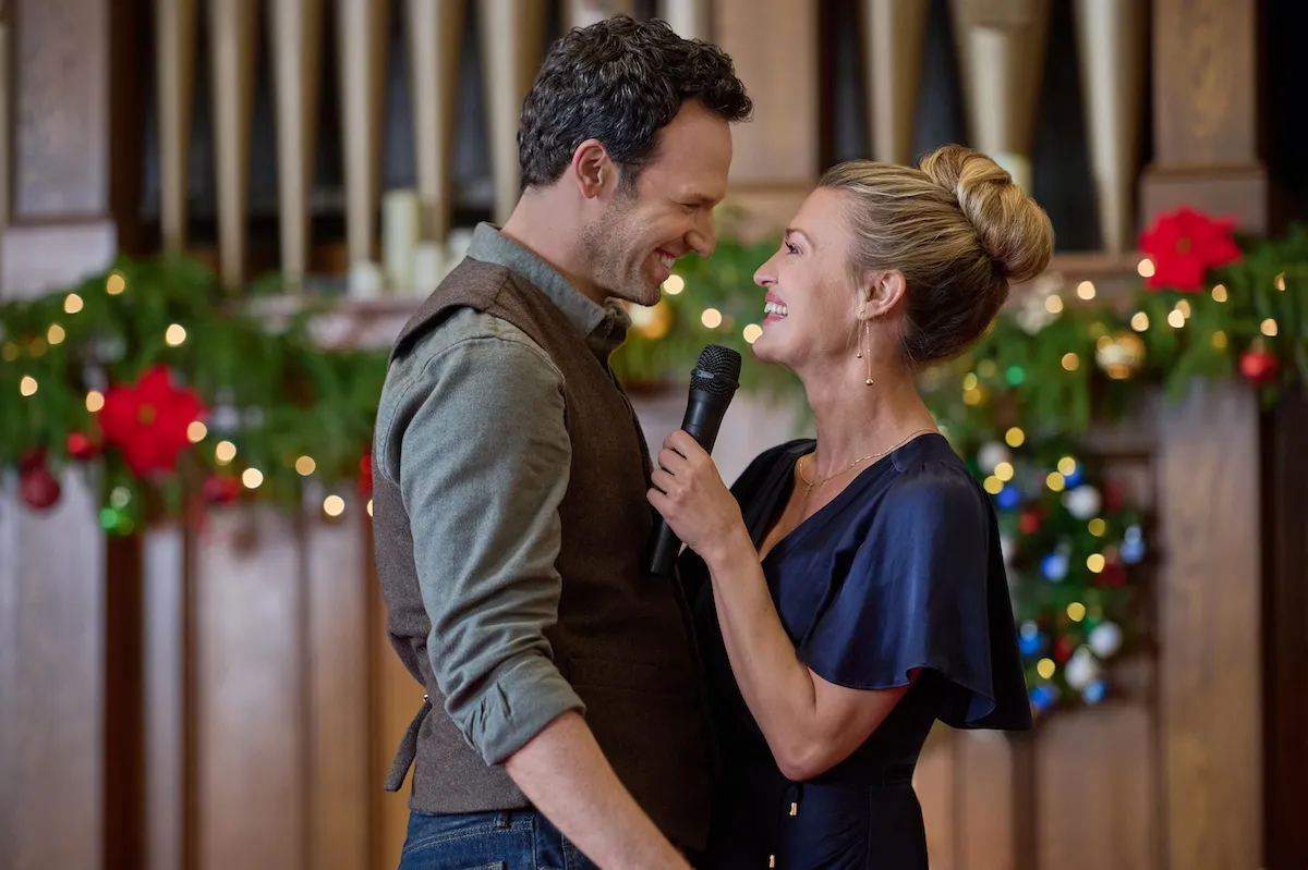 A man and a woman in a blue dress looking at each other in 'Oy to the World'