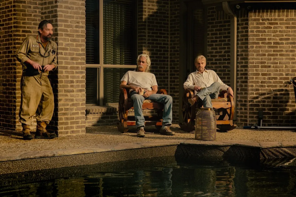 Three men, including Sam Elliott and Bill Bob Thornton sitting in lawn chairs, by the edge of an empty pool in 'Landman' Season 2