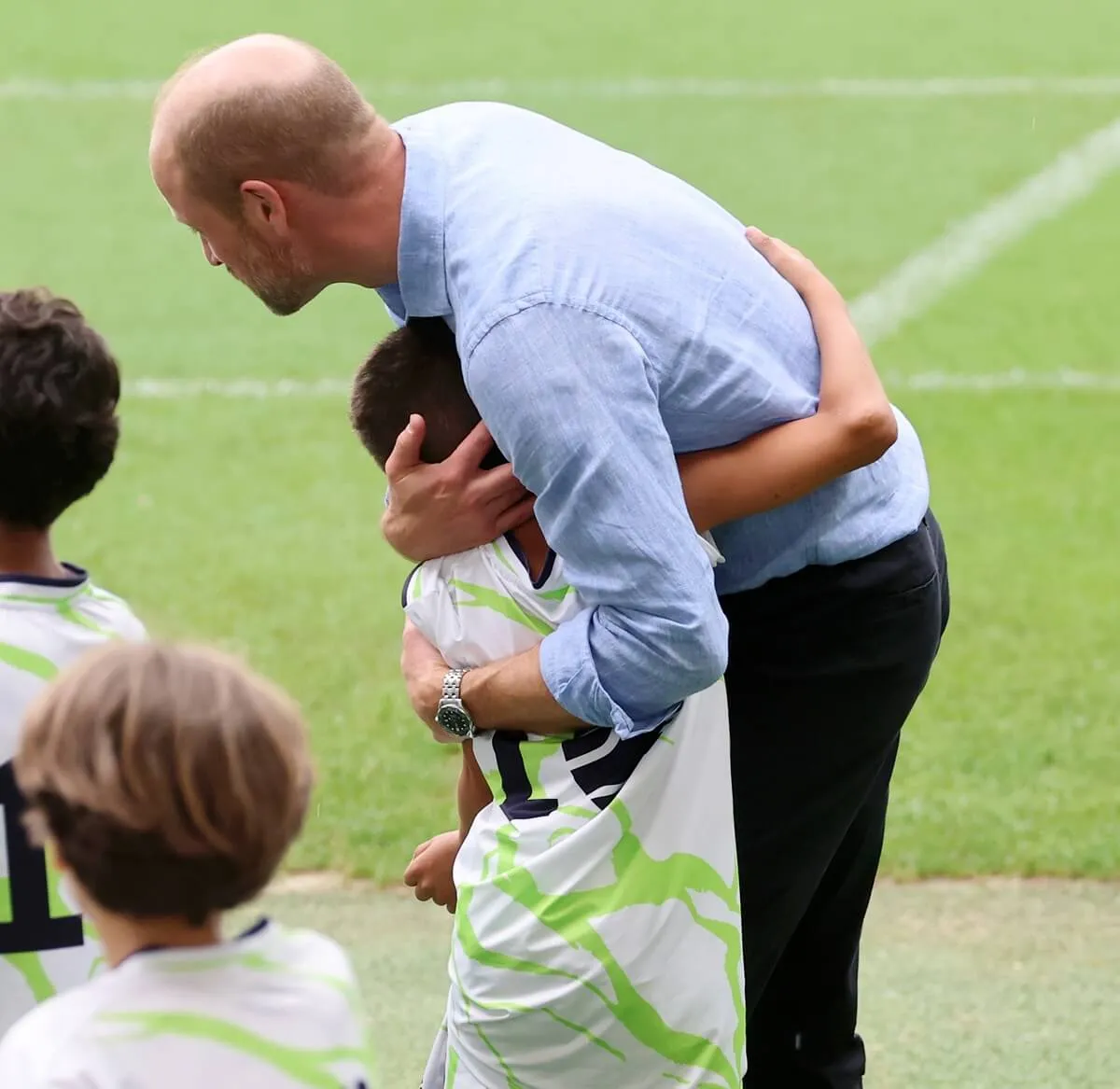 Prince William hugging a child from Terra FC (Earth FC) team