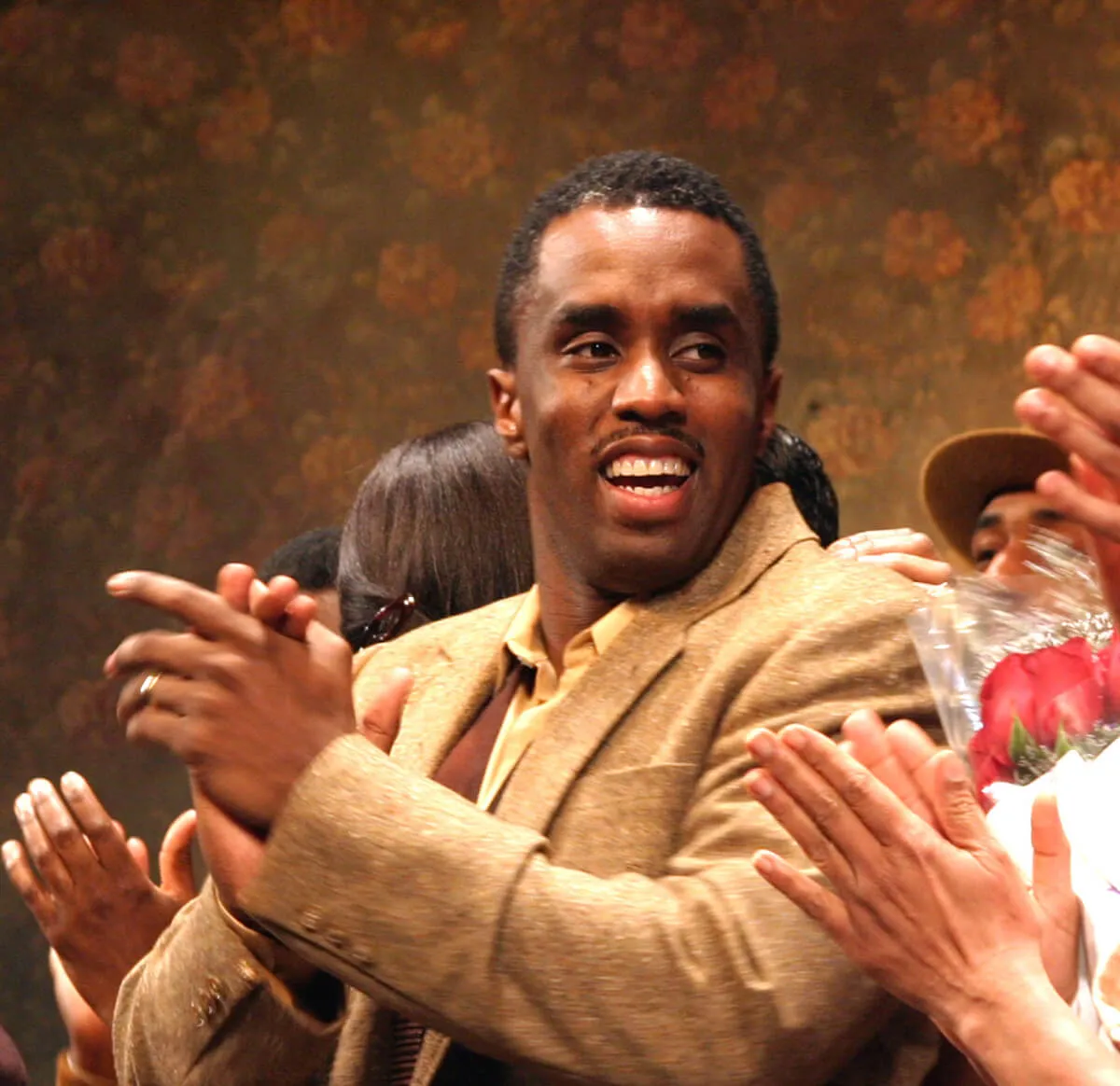 Sean 'Diddy' Combs stands on stage in a Broadway show and claps.