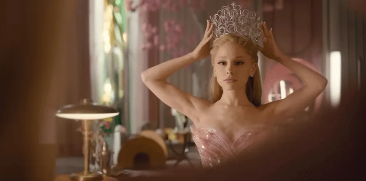 Screenshot of Ariana Grande placing a crown on her head in the 'Wicked: For Good' trailer.