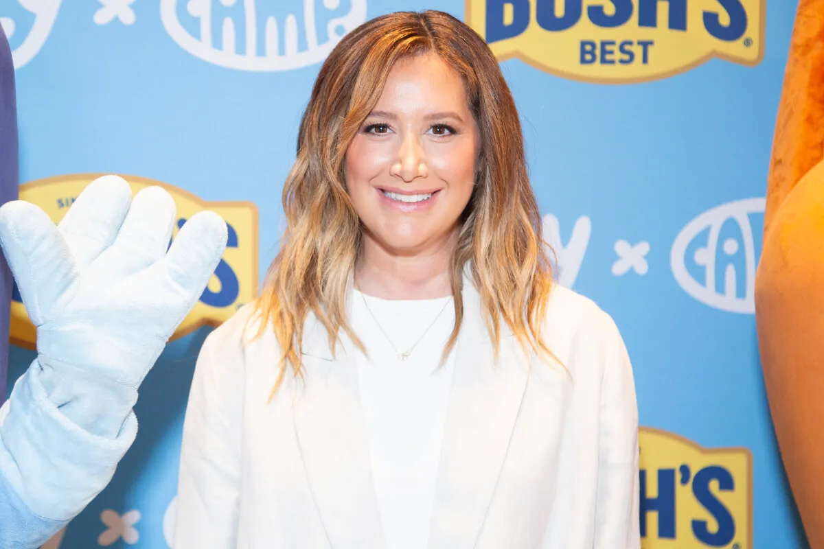 Ashley Tisdale wears a white shirt and white blazer.