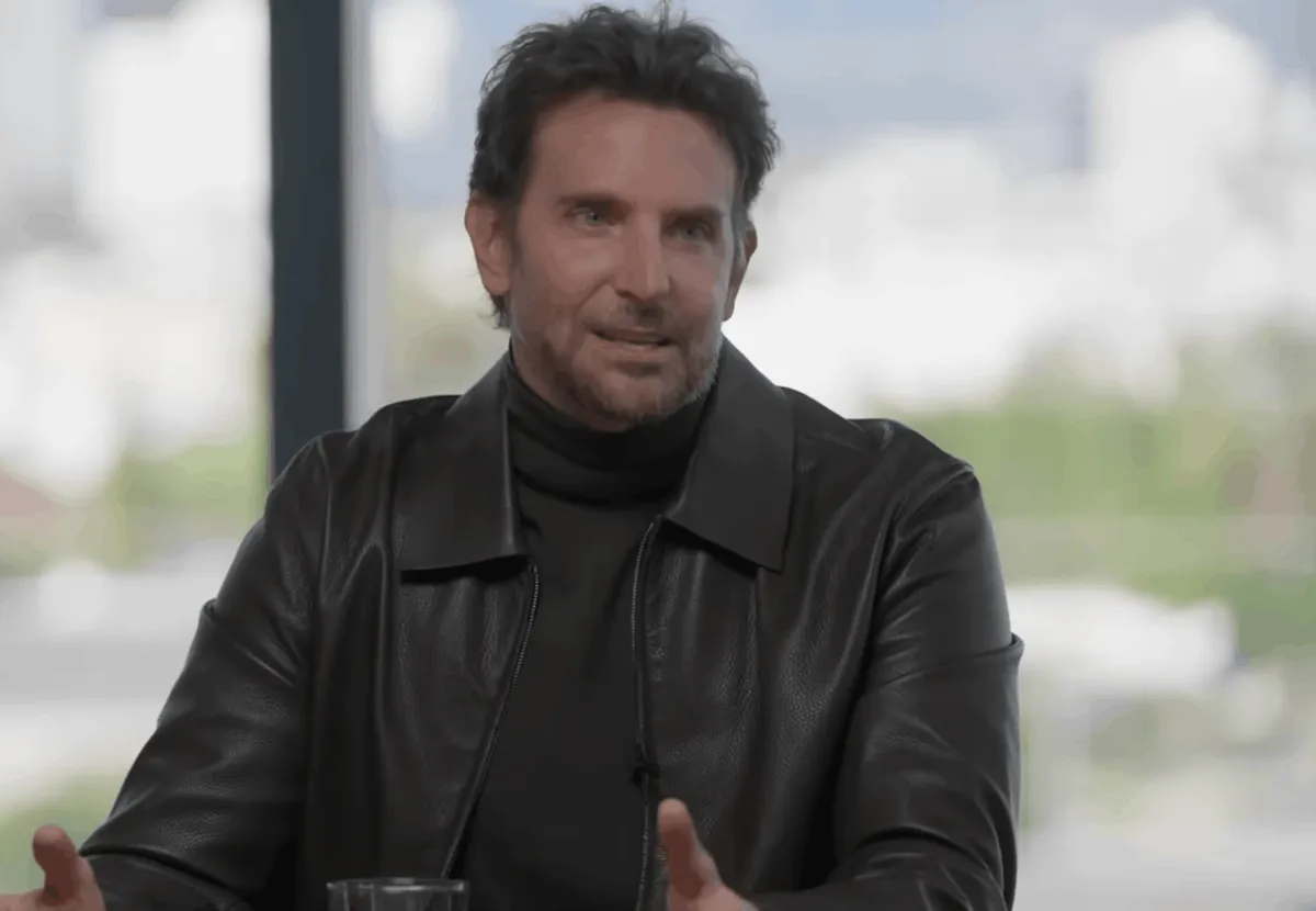 Wearing a leather jacket and turtleneck, Bradley Cooper sits at a table and discusses acting during a Hollywood Reporter Writer Roundtable