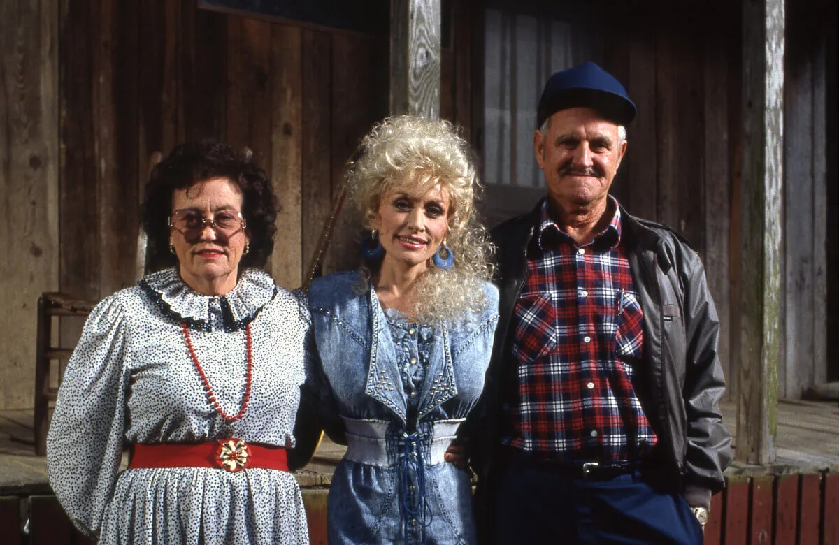 Dolly Parton stands between her mom, Avie Lee, and her dad, Lee.