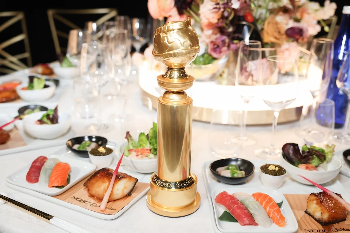 Golden Globe award on a table surrounded by plated food
