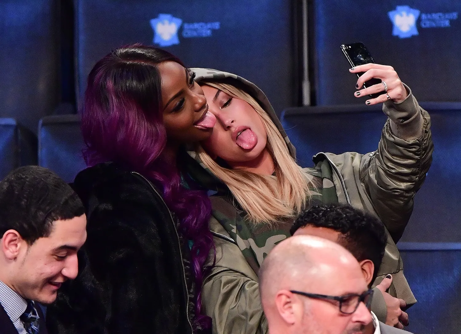 Hailey Bieber posing for a selfie with a friend at an NBA game in 2016. She's sticking her tongue out.