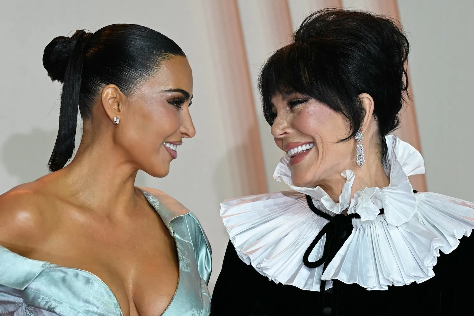 Kim Kardashian and mother Kris Jenner facing each other and smiling at photocall for 'All's Fair'