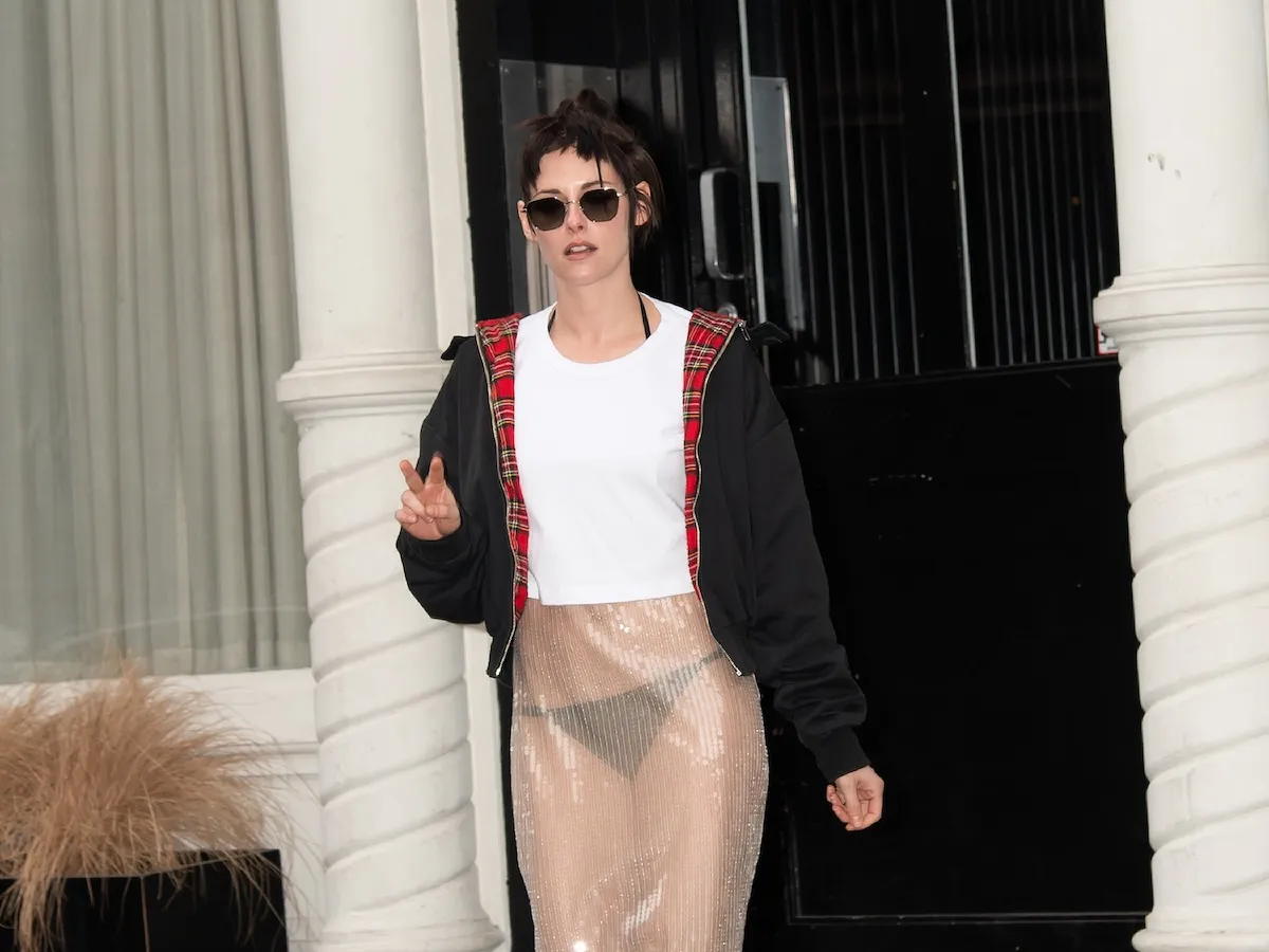 Kristen Stewart in a sheer dress, white tank top, and black jacket