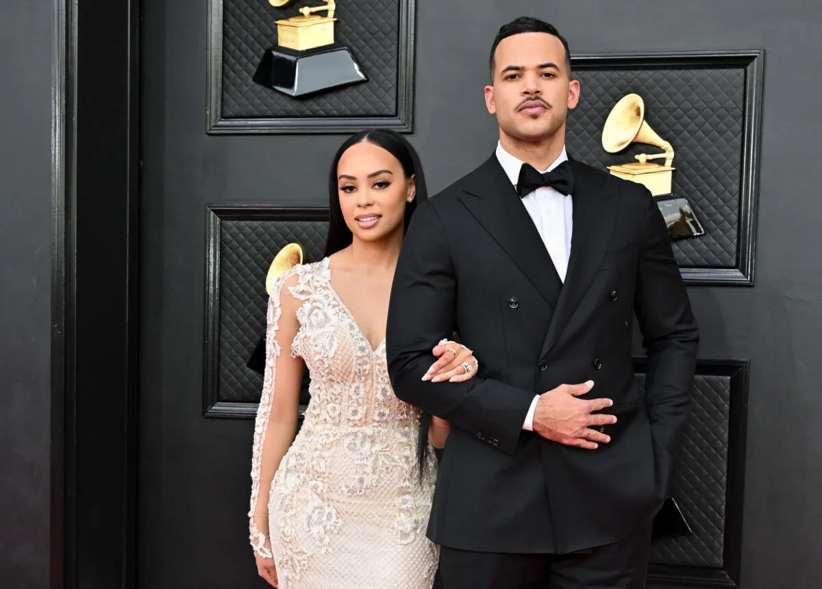 Kristy Scott wears a white dress and stands with her husband, Desmond Scott. He wears a tuxedo.