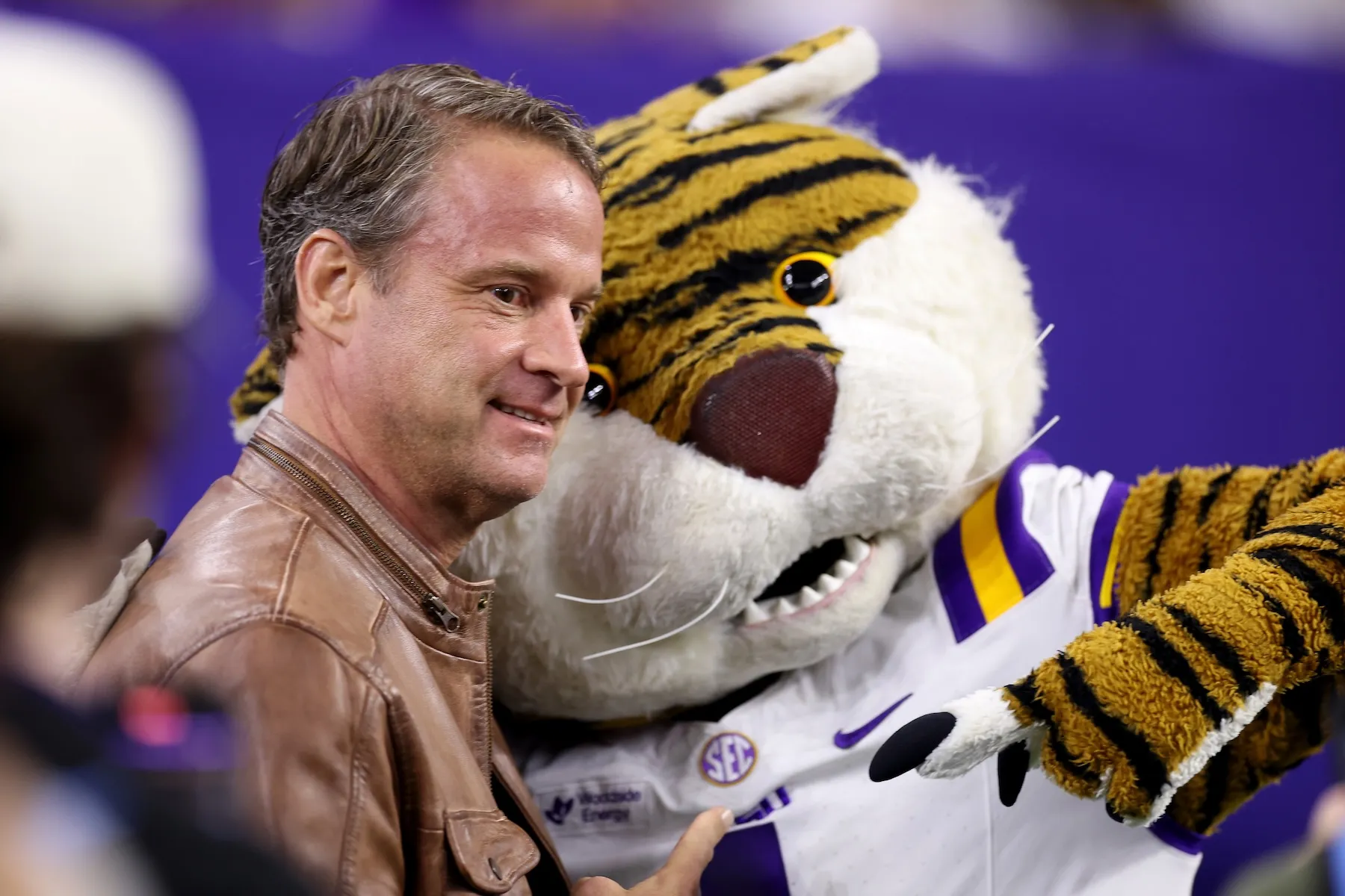 Head coach Lane Kiffin of the Louisiana State Tigers poses with the mascot