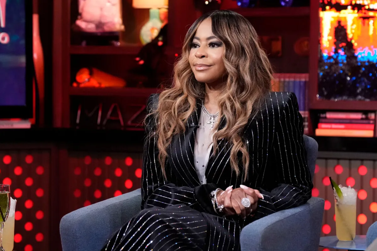 Mary Cosby wears a pinstriped suit and sits in an armchair.