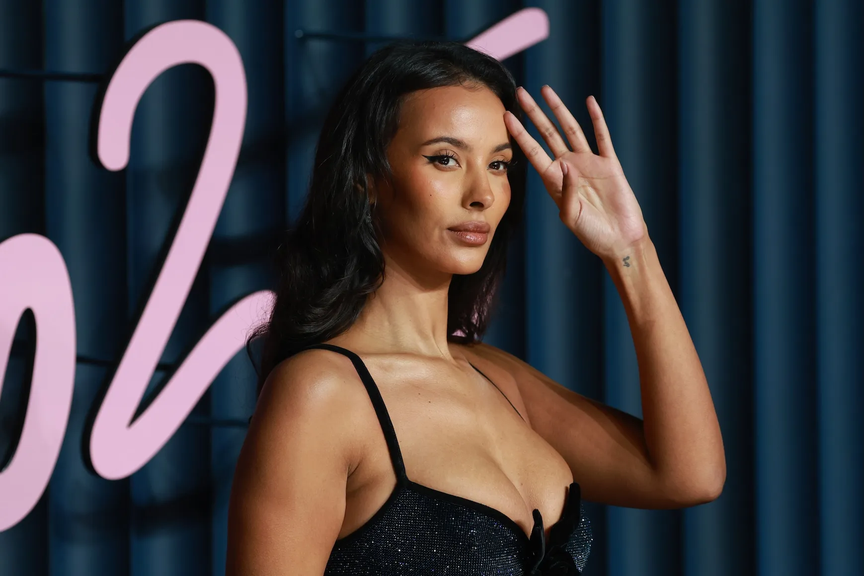 Maya Jama at an awards show in 2025. She's wearing a black dress.