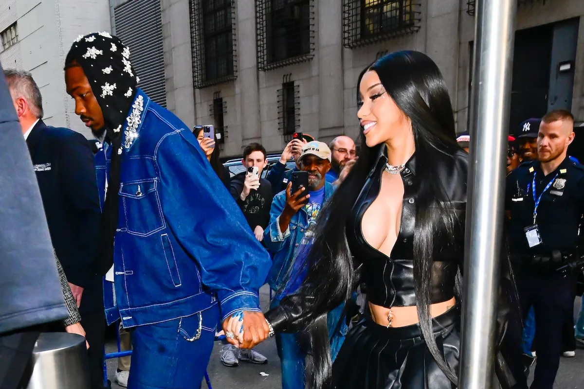 Stefon Diggs and Cardi B holding hands as they walk through Madison Square Garden in May 2025