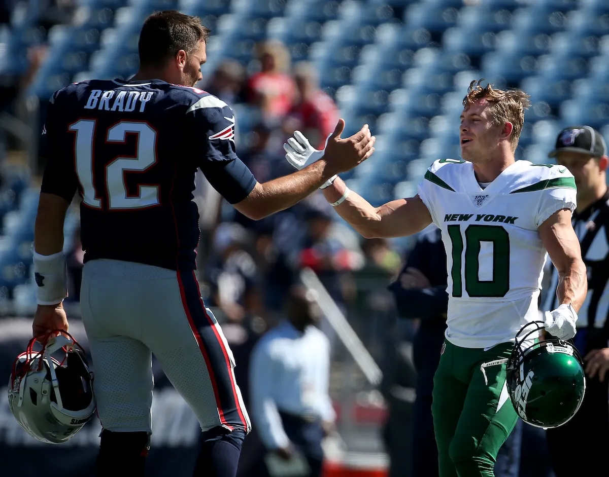 New England Patriots quarterback Tom Brady greets Braxton Berrios on the field