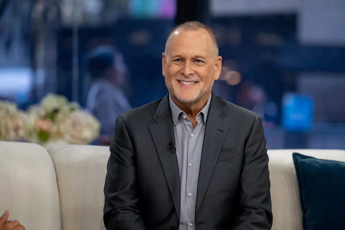Dave Coulier on 'TODAY' in 2024. He's smiling and wearing a suit while sitting on a couch.