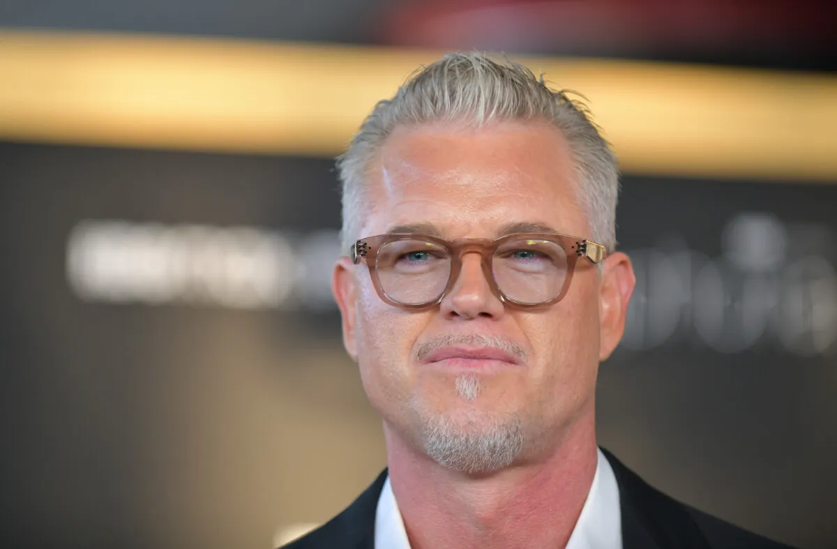 Eric Dane wears brown glasses and a suit.
