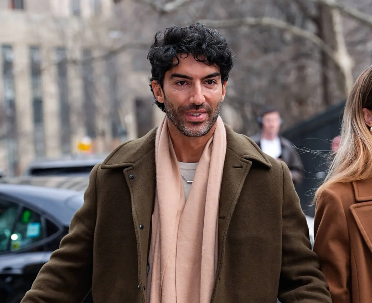 Justin Baldoni wears a brown coat and stands outside a mediation session with Blake Lively.