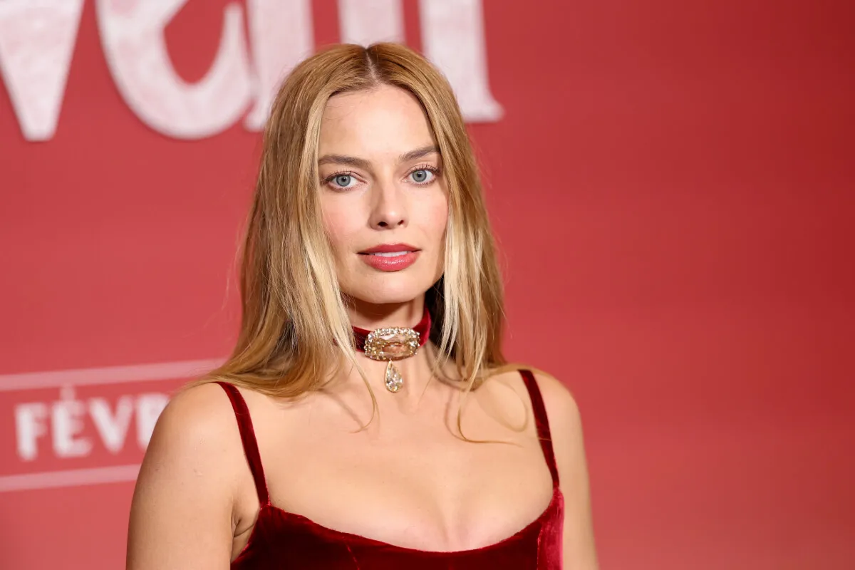 Margot Robbie wears a red dress and red choker necklace.