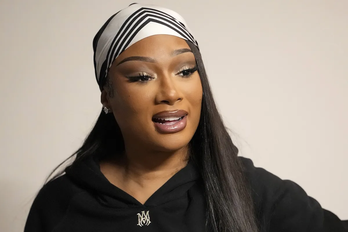 A close-up of Megan Thee Stallion with a striped wrap on her head