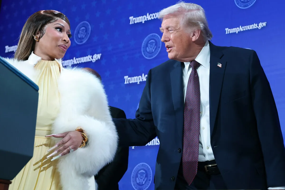 Nicki Minaj wears a yellow dress and white fur coat. She stands with Donald Trump, who wears a suit.