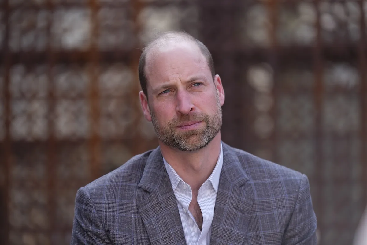 Prince WIlliam wearing a jacket and white shirt without a tie