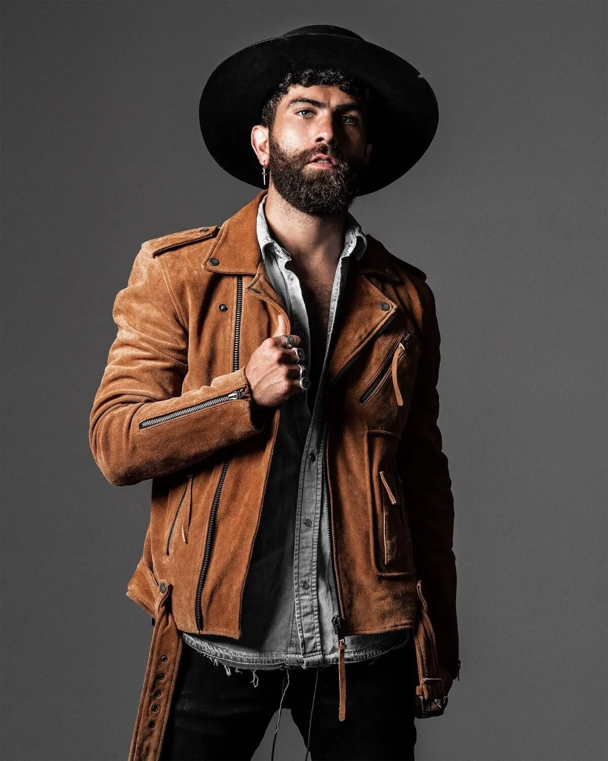 Reza Jackson of 'The Valley: Persian Style' wearing a brown leather jacket and black hat