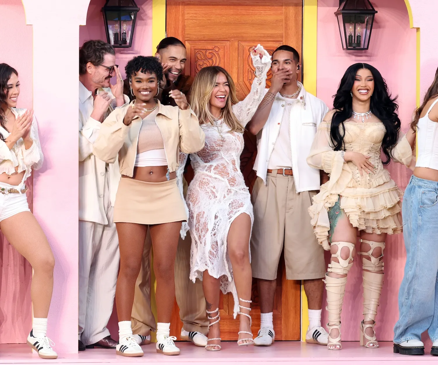 Super Bowl LX halftime show participants, including Pedro Pascal, Karol G, and Cardi B, dancing on a pink stage.