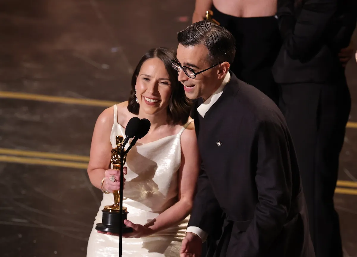 A woman and a man accepting an award at the 98th Oscars on March 15, 2026