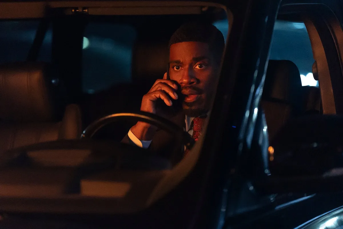 Man in a car talking on a cell phone in 'Beauty in Black' Season 2 Part 2