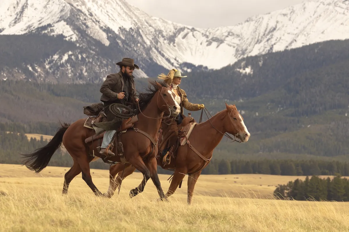 Beth (Kelly Reilly) and Rip (Cole Hauser) riding horses in front of snow-capped mountains in the 'Yellowstone' spinoff 'Dutton Ranch'