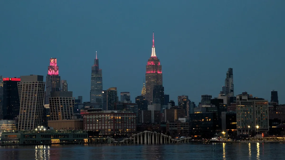 Buildings across the skyline of midtown Manhattan, including the Empire State Building, display various shades of pink and red to mark Valentine's Day in New York City on February 14, 2026, as seen Hoboken, New Jersey