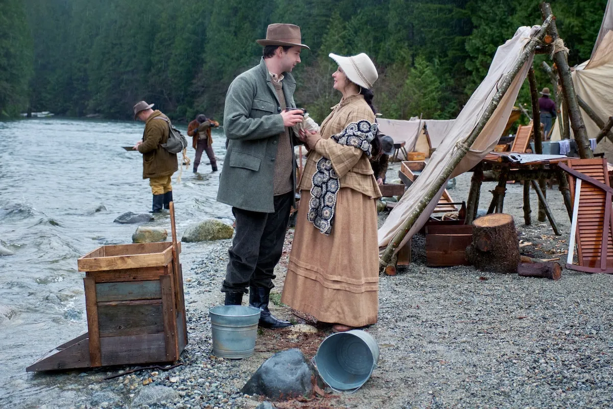 A pioneer couple standing by a river in 'Hope Valley: 1874'