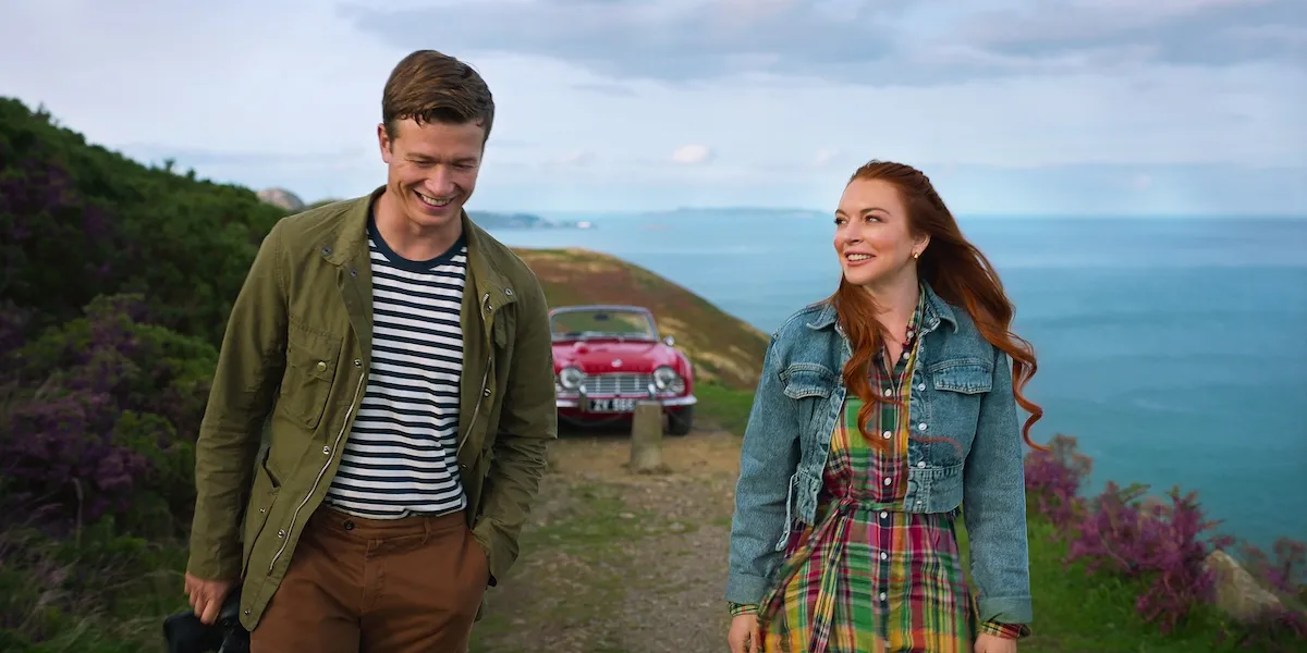 Ed Speleers and Lindsay Lohan standing on a road with the Irish coast in the background in 'Irish Wish'