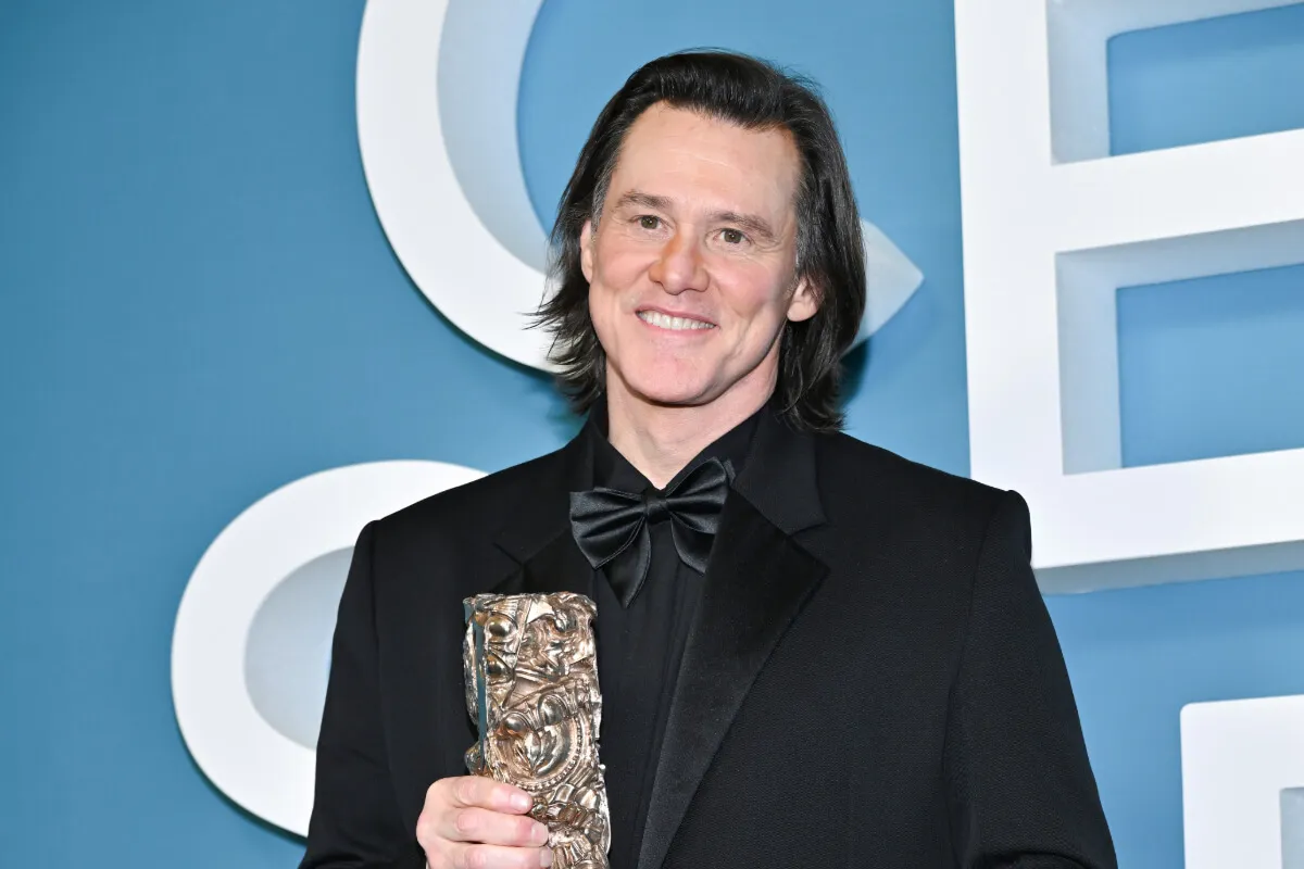 Jim Carrey wears a black suit and holds a Cesar award.