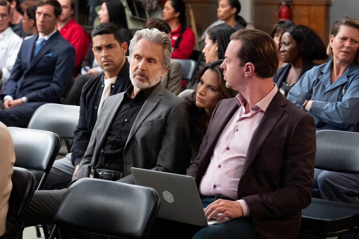 Gary Cole and Brian Dietzen sitting next to each other in an auditorium in the 500th episode of 'NCIS,' titled 'All Good Things'