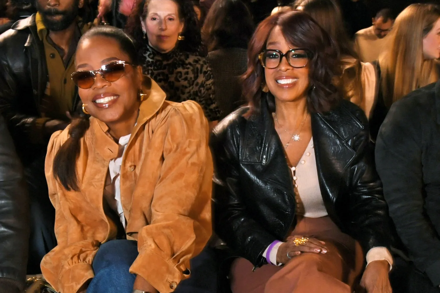 Oprah Winfrey and Gayle King sitting next to each other and smiling at Paris Fashion Week in 2026