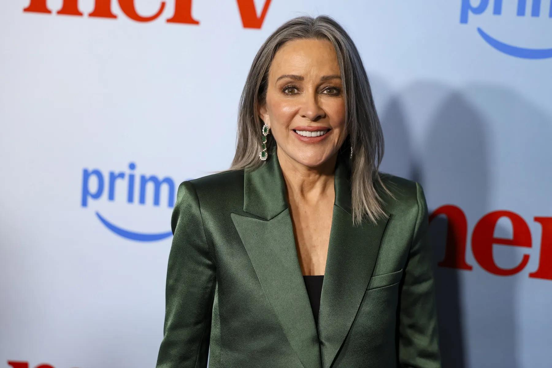 Patricia Heaton smiling at a premiere. She's wearing a green blazer and her hair is gray.