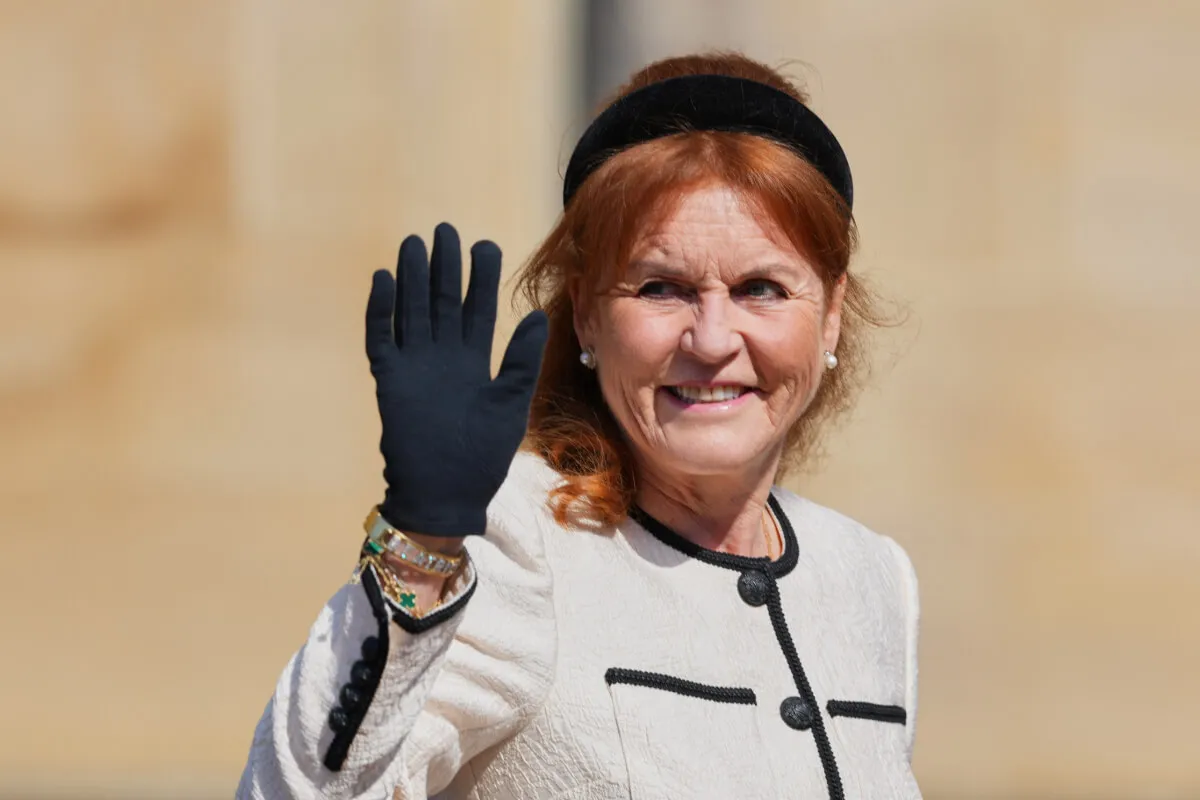 Sarah Ferguson wears a white jacket with black headband and black gloves.