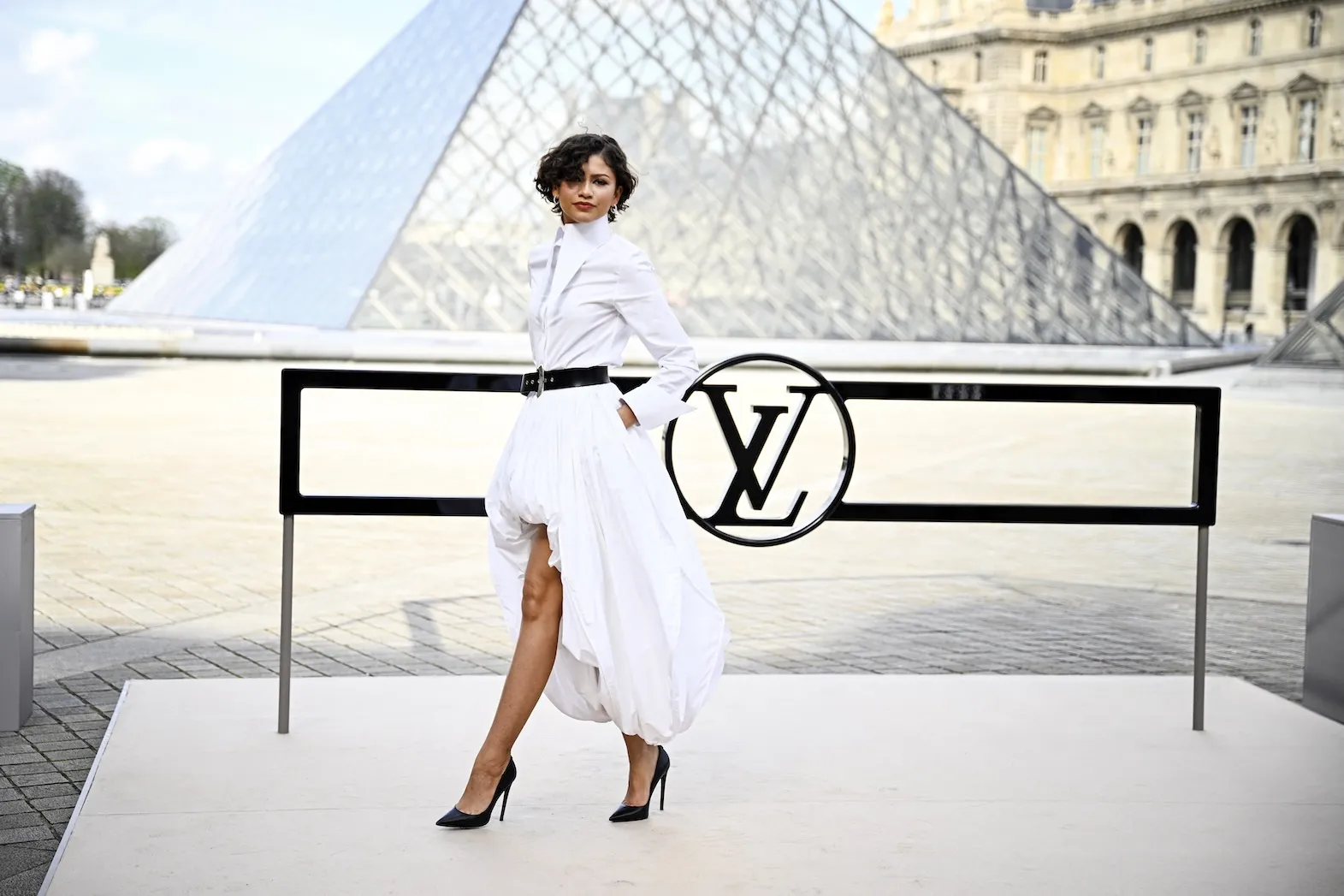 Zendaya poses during a photocall prior to attending the Louis Vuitton Women's Ready to Wear Fall/Winter 2026-2027 collection fashion show. She's wearing a white dress.