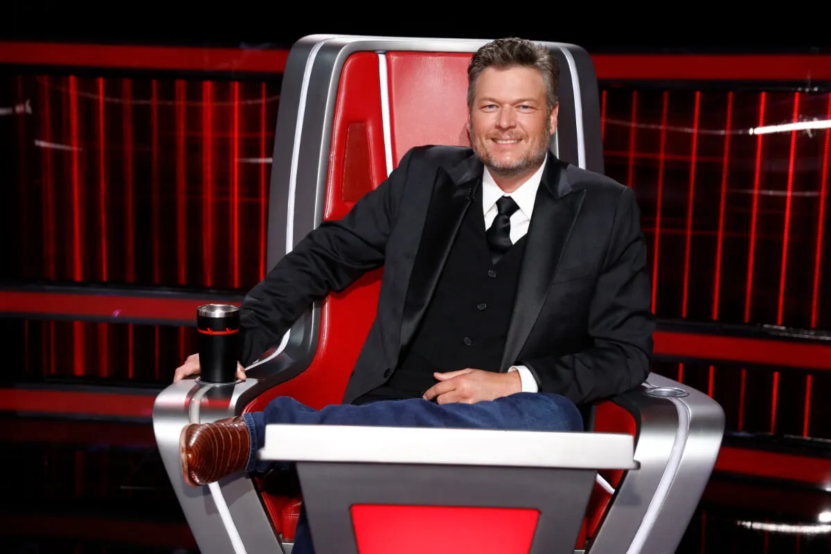 Blake Shelton wears a suit and sits in a red chair on 'The Voice.'