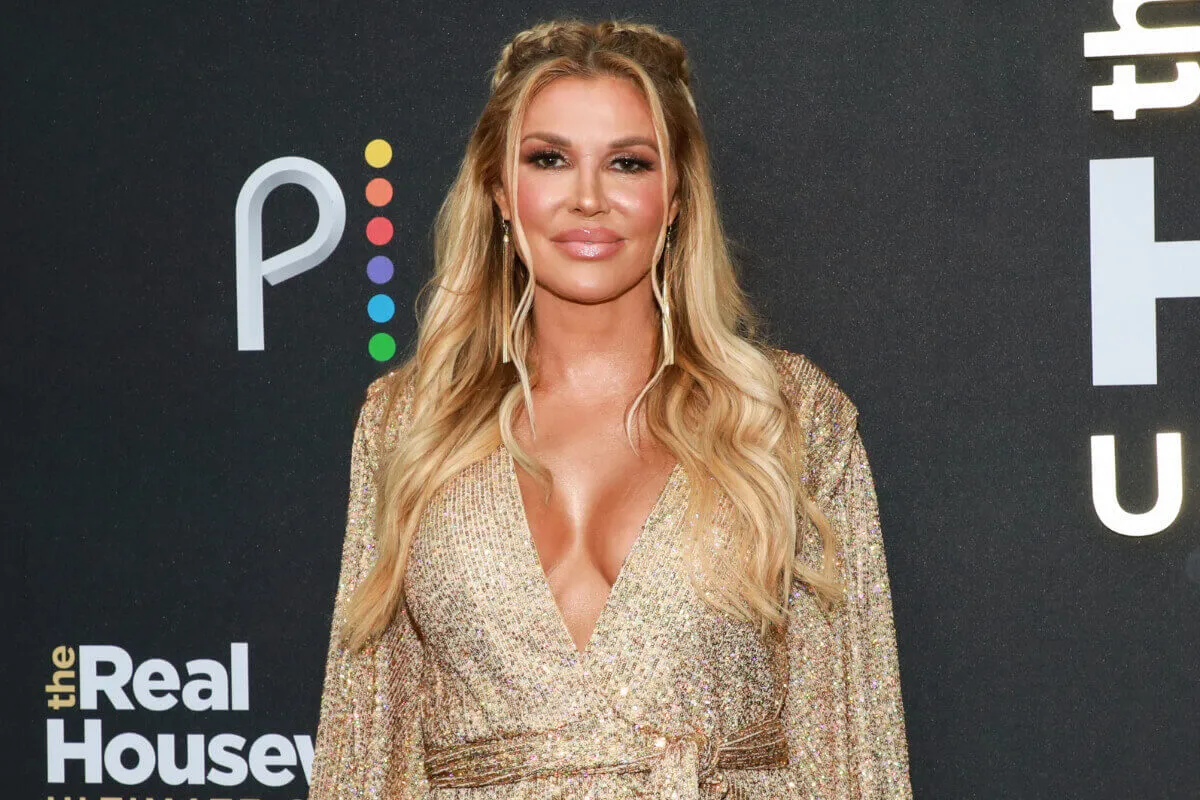 Brandi Glanville wears a gold sequined dress.