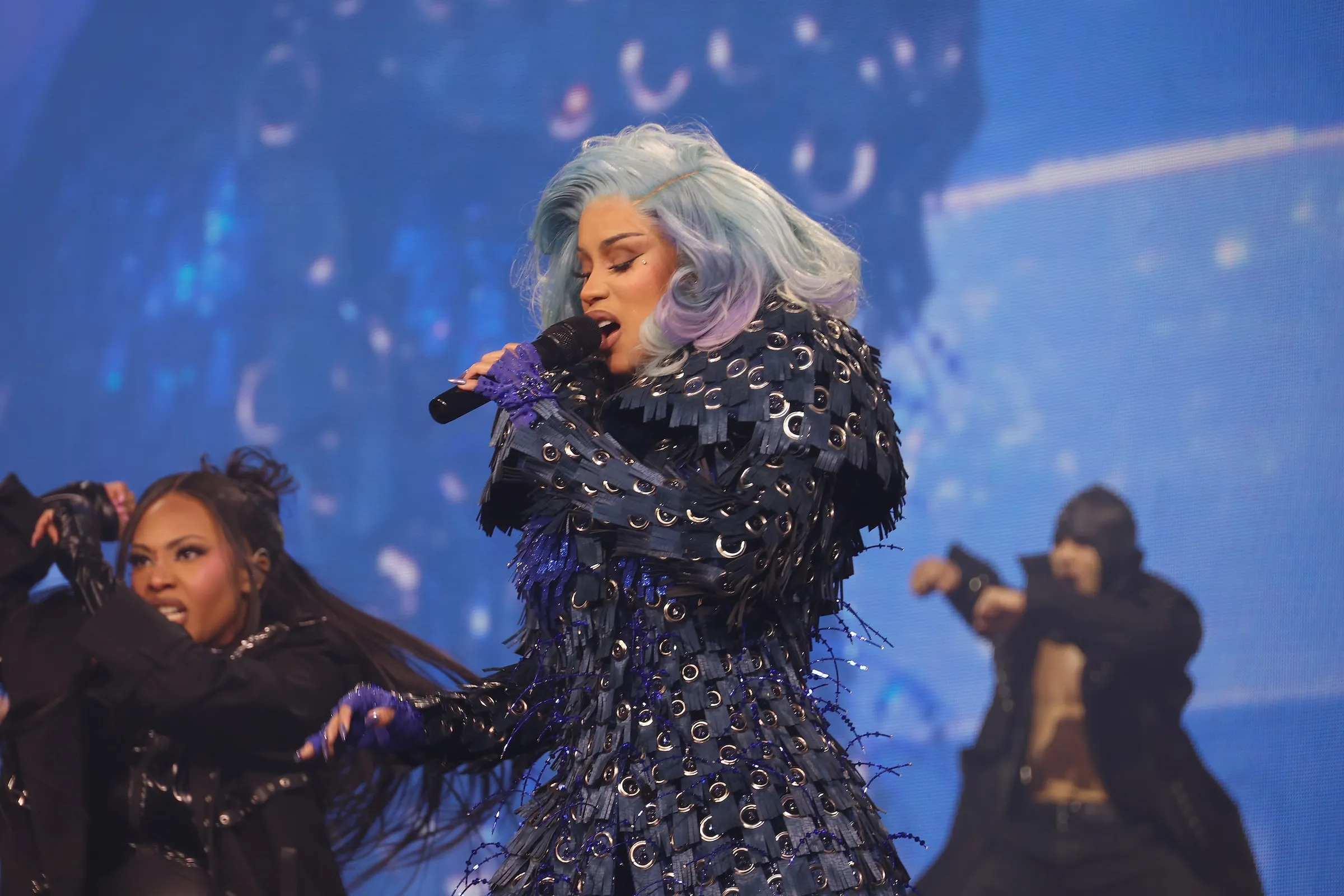 Cardi B singing into a microphone on stage