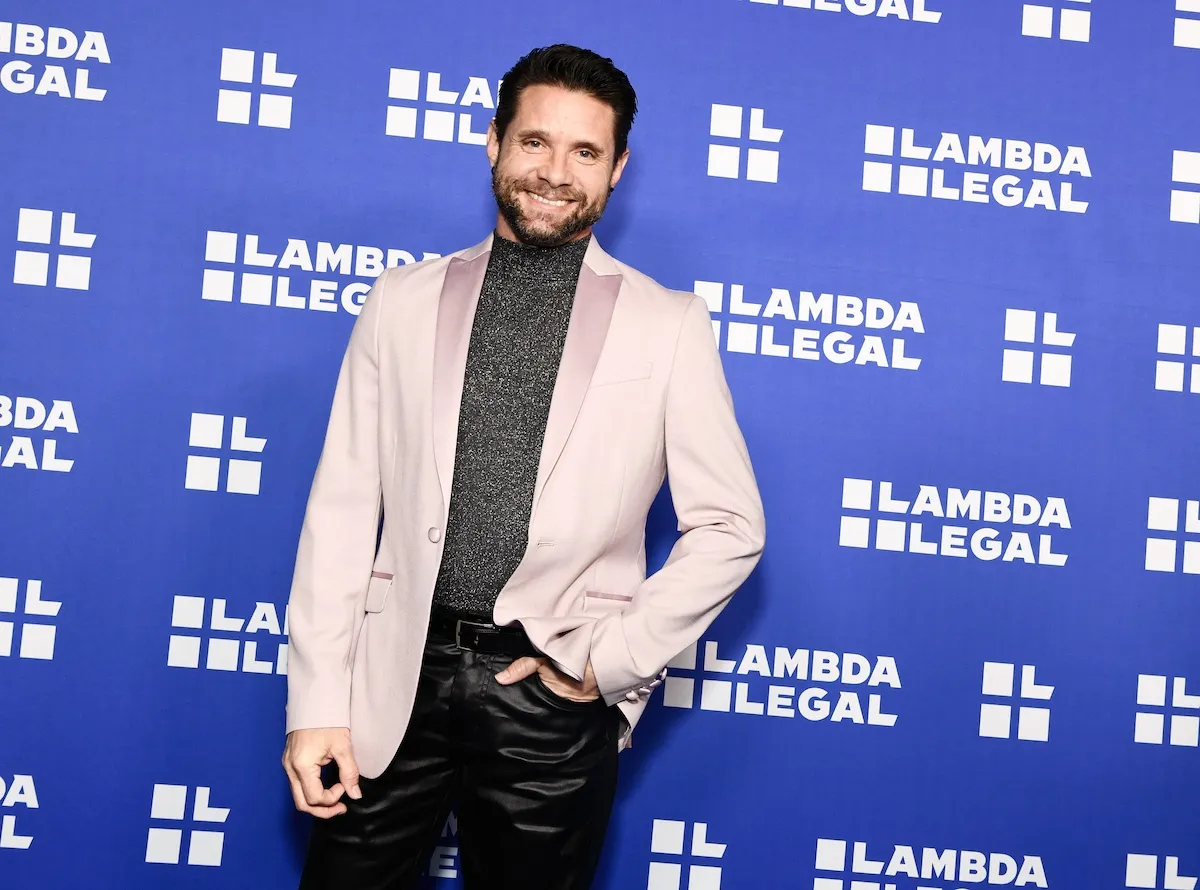 Danny Pintauro, in a white jacket, poses for a photo at an event