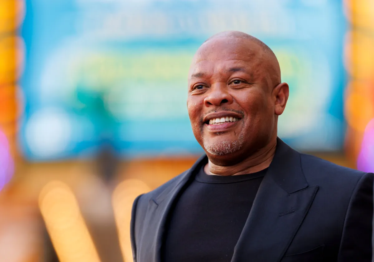 Dr. Dre wears a black shirt and a black suit jacket.