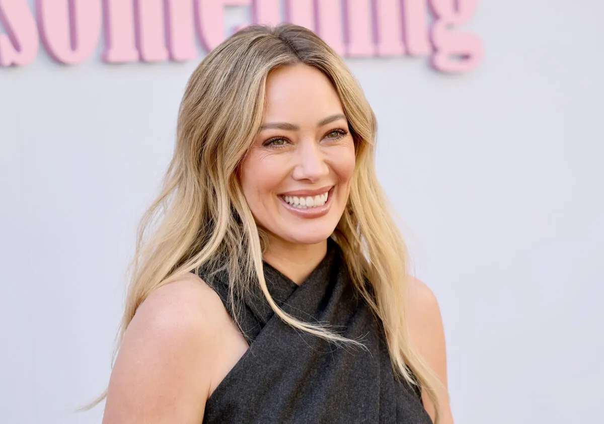 Hilary Duff wears a black halter top. She smiles.