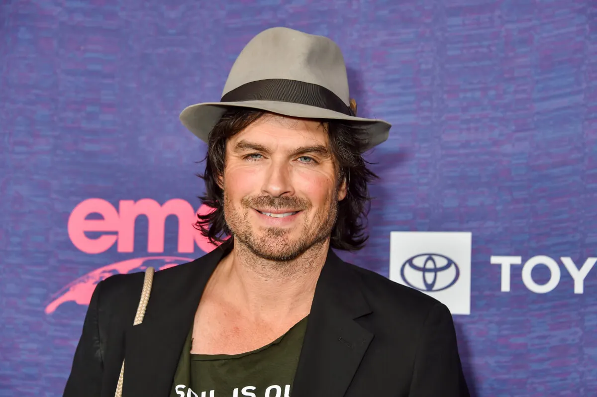 Ian Somerhalder wears a fedora and a black suit jacket.